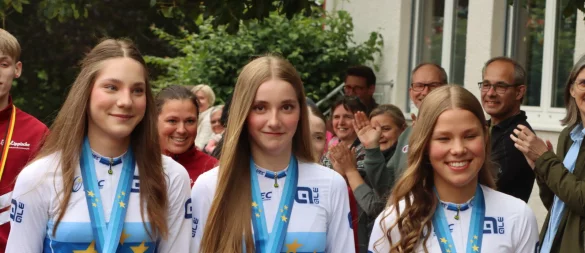 Antonia Blome, Maya Rudkoski und Melina Rethmeier (von rechts) sowie Trainerin Wibke Blome (im Hintergrund) laufen durch den Spalier und den roten Teppich an der Grundschule Lieme. - © Sebastian Lucas
