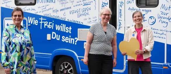 Gruppenleiterin Karin Hoffmann (von links), Pfarrerin Claudia Schreiber sowie Antje Krone vom Blauen Kreuz Lemgo stehen vor dem "Blauen Mobil". - © Jörg Hagemann