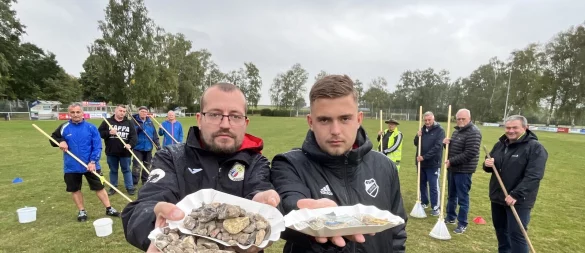 Timo Lenniger (links) und Erik Tappe zeigen einen Teil der Steine, Scherben, Plastik- und Metallstücke, die Mitglieder des VfL Lieme bereits vom Sportplatz geklaubt haben. Am Dienstag wurde die Aktion abgebrochen, man kapituliere vor der unmöglichen Aufgabe, heißt es von Seiten des Vereins. - © Till Brand