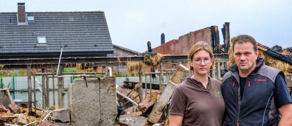 Drei Tage nach dem Großbrand auf dem Pferdehof sind Johanna und Jan-Wilhelm immer noch geschockt. Hier stehen sie vor dem abgebrannten Stall und dem Wohnhaus. Eins ist aber klar: "Pferdehaltung wird hier bei uns weitergehen", sagt der 40-Jährige. - © Kathrin Weege