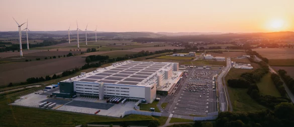 Erst aus der Entfernung wird richtig deutlich, wie groß das Amazon-Logistikzentrum PAD2 bei Belle (im Hintergrund) ist. - © Amazon