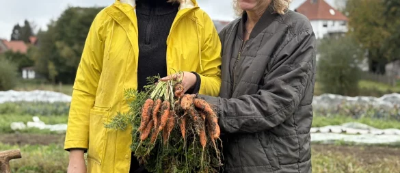 Ankristin Beineke (von links) und Maren Kaschka zeigen frisch geerntete Möhren vom Acker der Solawi in Langenholzhausen. - © Jan Schillmann