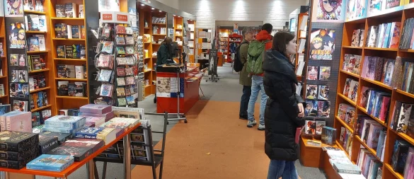 Gemeinsam stöbern entlang der Regale: Juna (r.) und ihr Vater Roman George und Sohn Molin (3. und 4. v. r) aus dem Rhein-Lahn-Kreis verbringen den Familienurlaub in der Region. Und gönnen sich den Abstecher in die Warburger Buchhandlung Podszun. - © Dieter Scholz