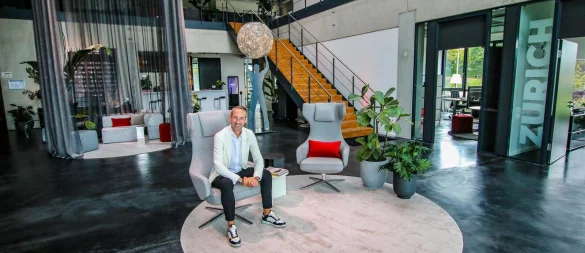 Tino J. Röse ist der Kopf von "emotions4life". Vor 15 Jahren gründet er das Unternehmen und arbeitet sich Jahr für Jahr immer weiter an die Spitze seiner Branche hoch. Hier sitzt er in der „Media Gallery“, die gleich mehrere Hingucker zu bieten hat – darunter ein von der Decke hängender Vorhang, der sich elegant um eine Sofalandschaft windet. - © Daniel Salmon