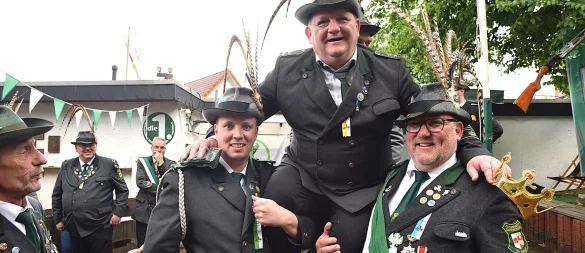Nach dem entscheidenden Schuss wird Sören Grote als neuer Schützen-Kaiser von Simon Maske (l.) und seinem Bruder Robin Grote auf die Schultern genommen und durch die Reihen getragen. - © Karin Prignitz