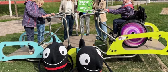 Mathilda (rechts) und ihre Geschwister Jonathan und Antonia (links) sind begeistert über die neue Inklusionswippe im Bürgerpark Lage. Mit den Kindern freuen sich (von links) Luba Schmidt und Uwe Friedrichsmeier vom Fachteam Straßen, Sportplätze, Friedhöfe und Werksstudentin Süeda Bozdayi. - © Stadt Lage