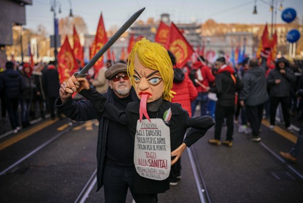 Ein Gewerkschafter hält eine Puppe mit dem Konterfei von Ministerpräsidentin Giorgia Meloni in die Höhe. - © Marco Alpozzi/LaPresse/AP/dpa