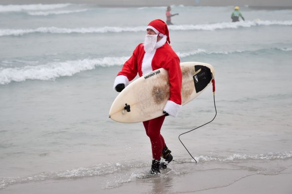 Events mit surfenden Weihnachtsmännern gibt es mittlerweile in mehreren Ländern. (Archivbild) - © Ben Birchall/PA Wire/dpa
