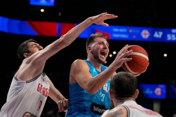 Luka Doncic (r) aus Slowenien wird vom Georgier Giorgi Shermadini gefoult. - © Hiro Komae/AP/dpa