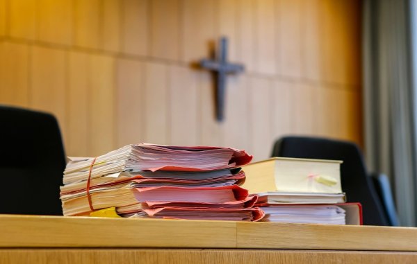 Akten liegen in einem Gerichtssaal auf dem Tisch. - © Uwe Lein/dpa/Symbolbild