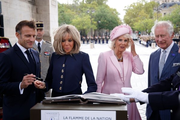 Präsident Emmanuel Macron (l-r) und und seine Ehefrau Brigitte Macron sowie Königin Camilla und König Charles III. von Großbritannien tragen sich während einer Zeremonie am Triumphbogen in Paris ins Goldene Buch ein. - © Yoan Valat/EPA POOL/AP/dpa