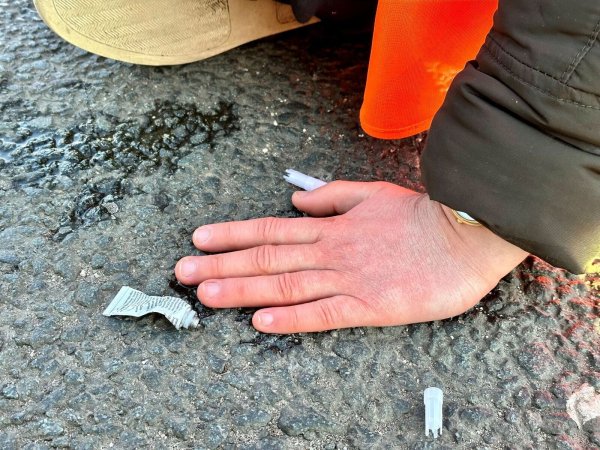 Eine Klimaaktivistin hat sich mit der Hand auf einer Hauptverkehrsstraße festgeklebt. - © Peter Zschunke/dpa-Zentralbild/dpa