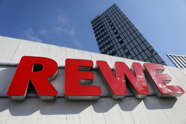 Ein Rewe Schriftzug hängt vor einem Supermarkt. - © Oliver Berg/dpa