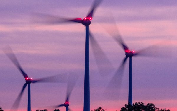 Mit Signallampen beleuchtete Windräder drehen sich nach Sonnenuntergang. - © Jens Büttner/dpa/Archivbild