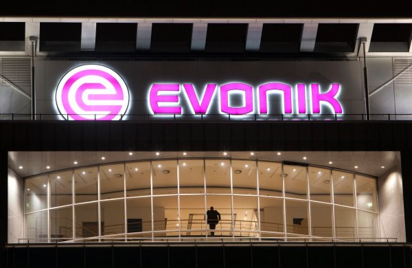 Das Logo von Evonik leuchtet an der Fassade der Firmen-Zentrale. - © Nico Kurth/dpa