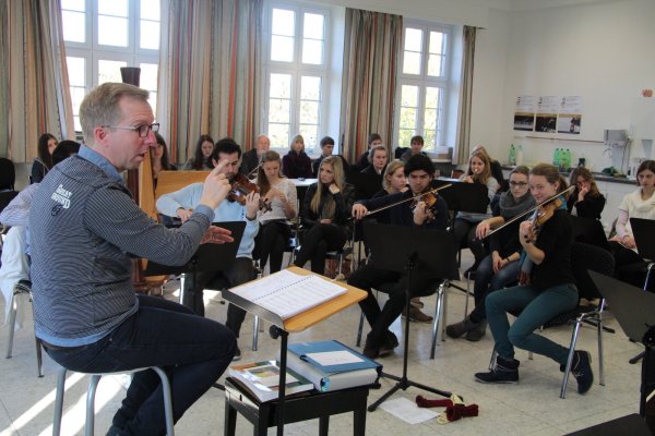 Intensive Arbeit am Werk: Guido Mürmann probt mit dem Detmolder Kammerorchester, Schüler und Komponisten hören genau zu. - © Barbara Luetgebrune