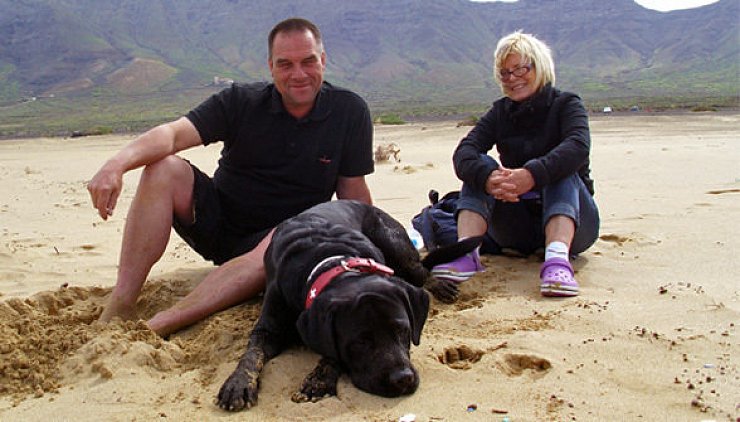 Das Urlaubsfoto zeigt Martin Schneider, Angelika Geigl-Schneider und Familienhund "Cody" beim Entspannen am Strand von Fuerteventura. - © Foto: Privat