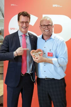 Ministerpr&auml;sident Hendrik W&uuml;st (CDU, l) und der SPD-Fraktionsvorsitzende Jochen Ott halten ein Lebkuchenherz in die Kamera. - &copy; SPD-Fraktion im Landtag NRW/dpa
