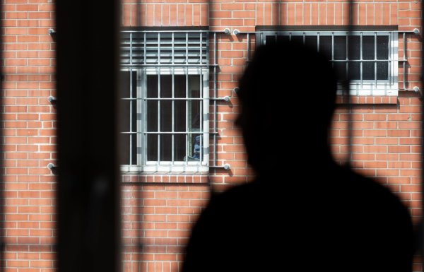Ein Insasse steht vor einem vergitterten Fenster in der Abschiebehaftanstalt in Büren. Ein 17-Jähriger aus Serbien war hier ebenfalls untergebracht. (Archivfoto) - © Friso Gentsch/dpa