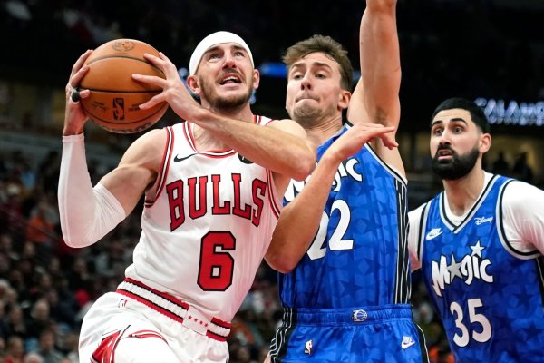 Alex Caruso (l) von den Chicago Bulls zieht zum Korb, während Franz Wagner von den Orlando Magic verteidigt. - © Charles Rex Arbogast/AP
