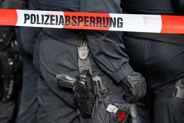 Polizisten stehen hinter einem Polizei-Flatterband. - © Hannes P. Albert/dpa