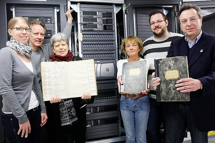 Vergangenheit und Zukunft: Das Team des Kreisarchivs, bestehend aus Ann-Catherine Stein, Dr. Hansjörg Riechert, Ulrike Lotze, Bettina Heidemann (von links) und Kurt Hagedorn (rechts), sowie Tim Pfeiffenberger, Administrator des Kreises Lippe, stehen mit alten Kassenbüchern vor den Servern, auf denen in Zukunft Archivgut abgespeichert werden könnte. - © Foto: Bockwinkel