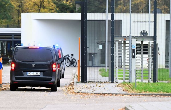 Mit eingeschaltetem Blaulicht fahren mehrere Wagen auf den Hof an der Außenstelle des Bundesgerichtshofs. - © Uli Deck/dpa