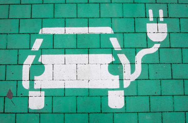 Ein Elektroauto auf grünem Grund markiert einen Parkplatz für Elektrofahrzeuge. - © Julian Stratenschulte/dpa/Symbolbild