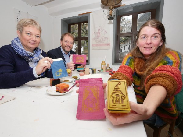 Probieren den Textildruck aus: Katharina Schlimmgen, Professor Dr. Jan Carstensen und Ulrike Loth (von links) testen eine der Mitmach- Aktionen des Museumsadvents. Ulrike Loth hält eine der Formen in die Kamera, mit denen die Kinder drucken können. - © Jost Wolf
