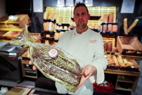 Bäckermeister Andreas Hermisch aus Paderborn hält den fertigen Dubai-Stollen in den Händen. - © Christoph Reichwein/dpa
