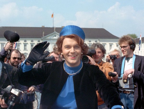 Verkleidet als Königin Beatrix winkt der deutsche Komiker und Showmaster Hape Kerkeling vor Schloss Bellevue für die Presse. (Archivfoto von 1991) - © picture alliance / dpa