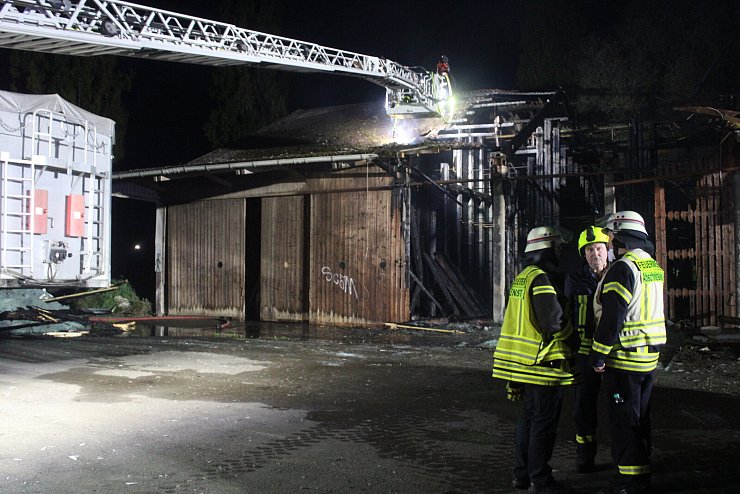 Lippes Kreisbrandmeister Wolfgang Kornegger (Bildmitte) lässt sich von Einsatzleiter Axel Sander (links) und Abschnittsleiter Dominik Kerscher über den aktuellen Stand der Löscharbeiten des Lagerhallenbrandes in der Schötmaraner Ladestraße berichten. Foto: Daniel Hobein / Feuerwehr Bad Salzuflen - © Feuerwehr Bad Salzuflen/Daniel Hobein