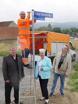 Wegweisend: Axel Friedrich vom Bauhof befestigt das Stra&szlig;enschild f&uuml;r den Luise-Rinsche-Weg. Sie war von 1929 bis 1932 f&uuml;r die SPD in den Lippischen Landtag gew&auml;hlt worden und in dieser Zeit die einzige Frau im Gremium. Ihre Enkelin Resi Fischer freut sich mit R&uuml;diger Scheu&szlig;, Ortsb&uuml;rgermeister von Pivitsheide VL (links) und SPD-Chronist Gerd Kaulvers &uuml;ber die Ehrung. Foto: Jost Wolf - &copy; Jost Wolf