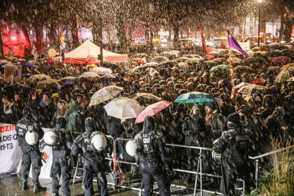 Demonstranten stehen an einem Absperrgitter vor dem Eurogress. - © Oliver Berg/dpa
