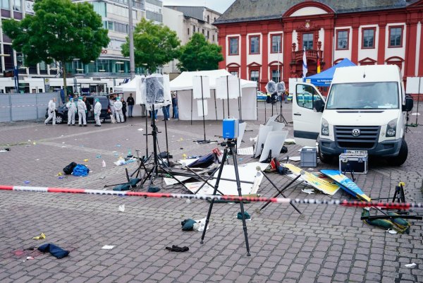 Mitarbeiter der Spurensicherung stehen auf dem Marktplatz hinter einem zertrümmerten Stand. - © Uwe Anspach/dpa