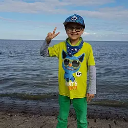 Ein Traum geht in Erfüllung: Der schwer erkrankte Oliver steht am Ufer der Nordsee und posiert mit seinem Victory-Zeichen für ein Foto. - © privat