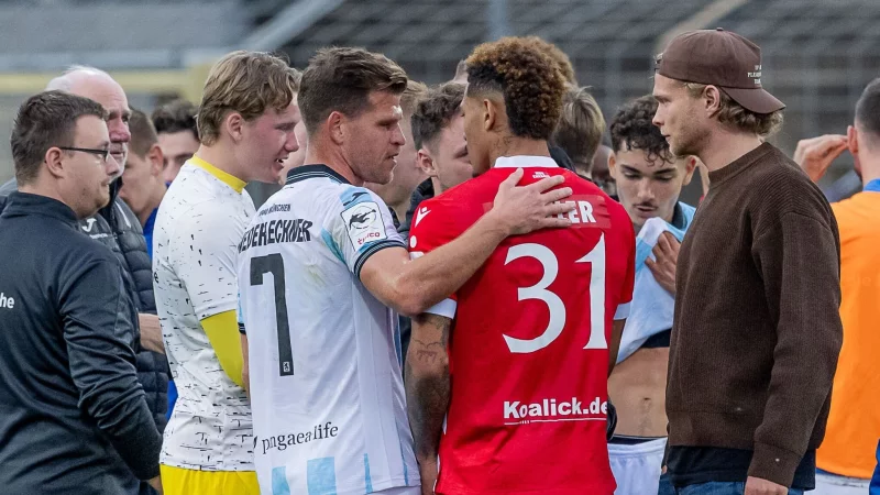 Florian Niederlechner (TSV 1860 M&uuml;nchen) spricht nach dem Rassismus-Vorfall aufmunternd mit Justin Butler (FC Energie Cottbus). - &copy; Heike Feiner/Eibner Pressefoto/dpa