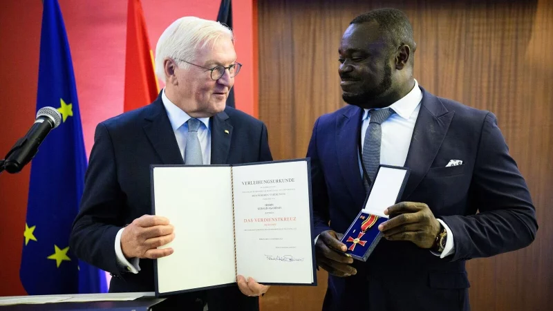 Der fr&uuml;here Fu&szlig;ball-Nationalspieler Gerald Asamoah (r) erh&auml;lt von Bundespr&auml;sident Frank-Walter Steinmeier das Bundesverdienstkreuz. - &copy; Bernd von Jutrczenka/dpa