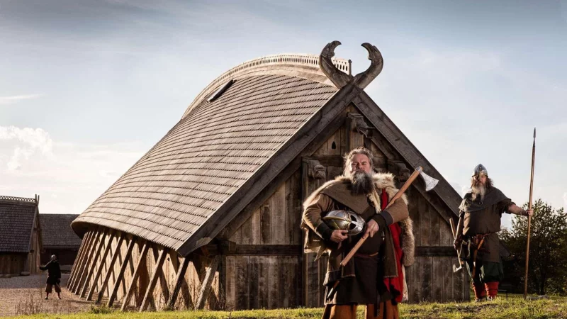 Zeitreise: Als Wikinger verkleidete Schauspieler stehen vor der K&ouml;nigshalle im &laquo;Land der Legenden&raquo;. - &copy; Sagnlandet Lejre/Visit Fjordlandet/dpa-tmn