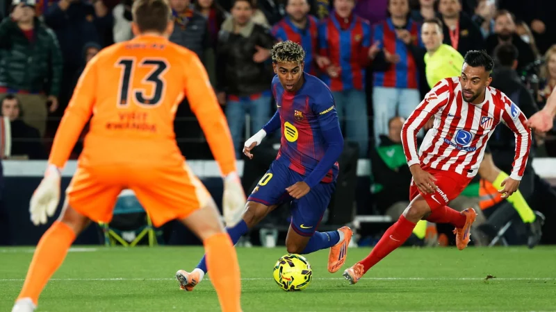 Barca-Star Lamine Yamal lieferte sich einige Zweikämpfe mit Atletico Madrids Carlos Martin. - © Joan Monfort/AP/dpa