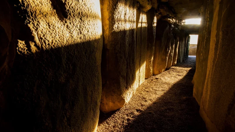 Sonne scheint in den Gang der Grabkammer von Newgrange: Zur Wintersonnenwende fällt das Morgenlicht besonders lang hier hinein. - © John Lalor/Photographic Archive/National Monuments Service/Government of Ireland/dpa-tmn