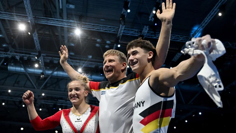 Karina Schönmaier und Trainer Anatol Ashurkov (M) jubeln mit Timo Eder über EM-Gold. - © Marijan Murat/dpa