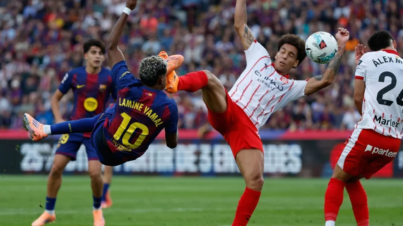 Barcelona mit Lamine Yamal (l) siegte gegen Girona mit dem früheren Dortmunder Axel Witsel. - © Joan Monfort/AP/dpa