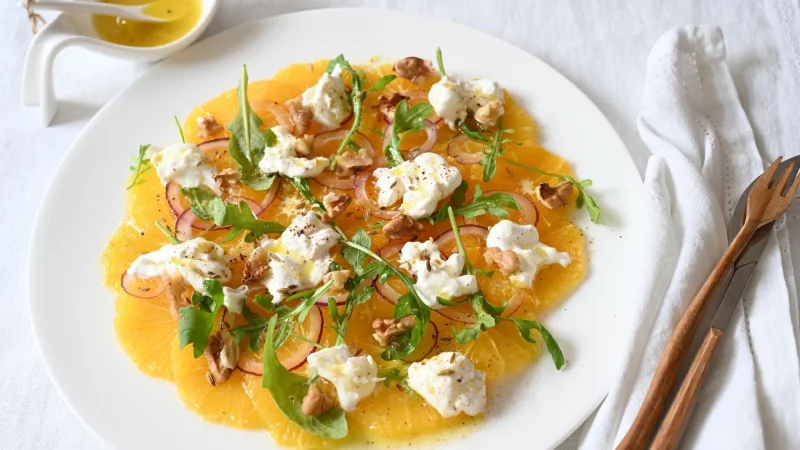 Erinnert an das Strahlen der Sonne: Das Orangen-Carpaccio ist nicht nur fruchtig, sondern verzaubert auch mit einem herzhaften Knoblauch-Kick. - © Julia Uehren/loeffelgenuss.de/dpa-tmn