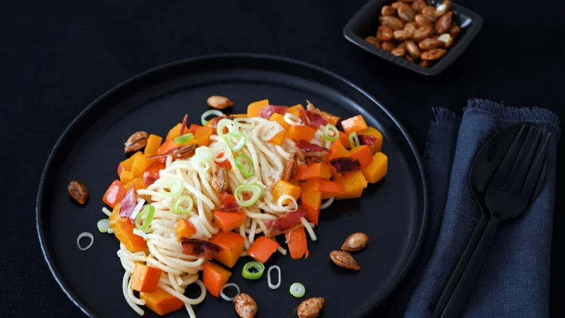 Eine ganze Knolle Knoblauch wird für die Herbst-Pasta zusammen mit dem Kürbis gebacken. So bekommt man eine tolle Karamellnote. - © Julia Uehren/loeffelgenuss.de/dpa-tmn