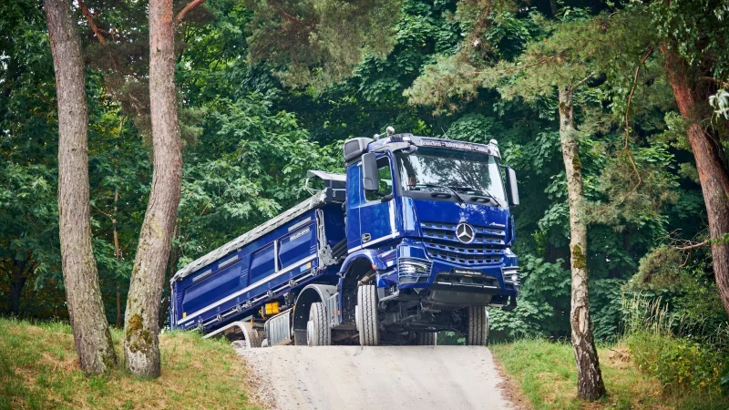 Über Hügel, Stock und Stein: Wer fernab gewöhnlicher Straßen Lasten bewegen will, greift zu Trucks wie dem Arocs 4151 von Mercedes. - © Frederik Dulay-Winkler/Daimler Truck AG/dpa-tmn