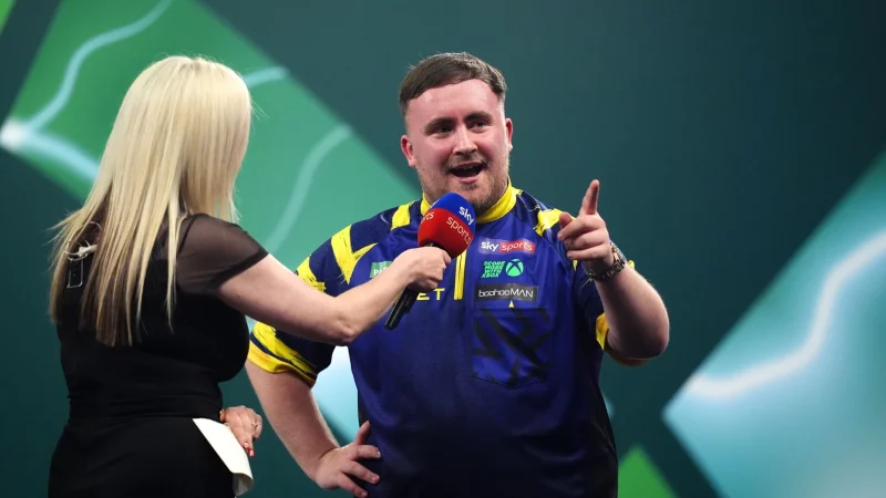 Gr&uuml;&szlig;e an die Fans: Weltmeister Luke Littler reagiert auf Buhrufe. - &copy; John Walton/PA Wire/dpa