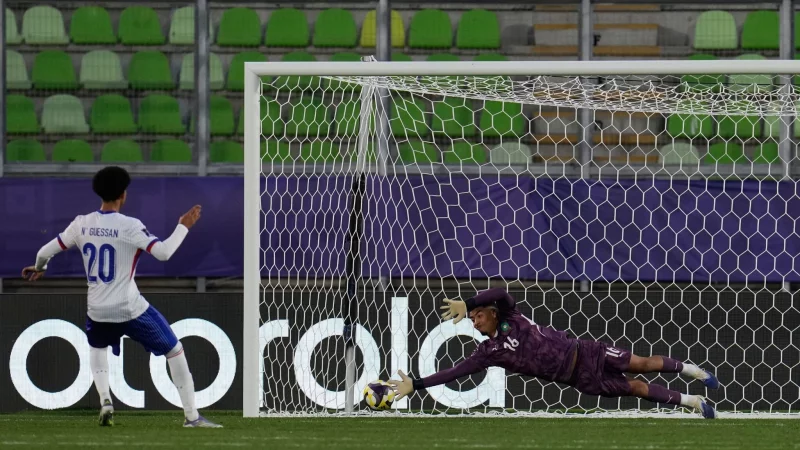 Marokkos Torhüter Abdelhakim Mesbahi hält einen Elfmeter. - © Matias Delacroix/AP/dpa