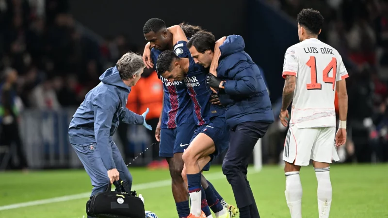 Auf Betreuer gest&uuml;tzt wird der am Fu&szlig; verletzte PSG-Spieler Achraf Hakimi (M) vom Platz gef&uuml;hrt. - &copy; Federico Gambarini/dpa