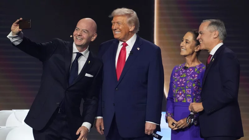 FIFA-Chef Gianni Infantino macht ein Selfie mit den Regierungschefs der drei WM-Gastgeber. - © Evan Vucci/AP/dpa